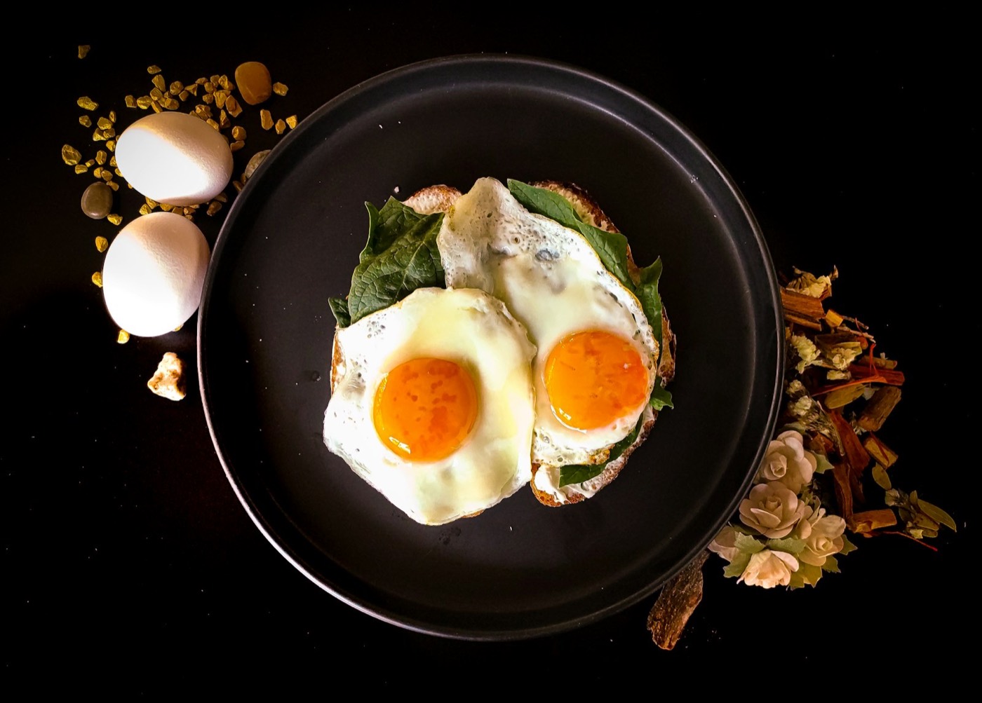 Sunny side up egg on a black ceramic plate — warm breakfast styling
